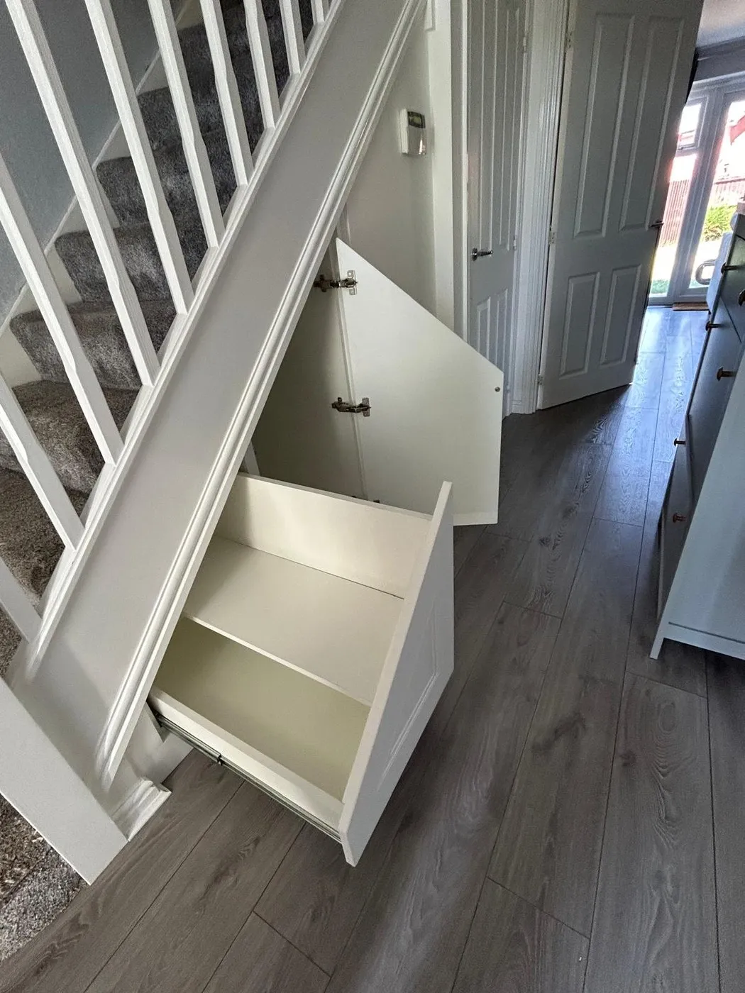 A white pull out drawer open with a floating shelf inside