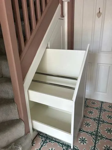 A deep shelved pull out drawer extended beside a pink balustrade, at a height children can reach