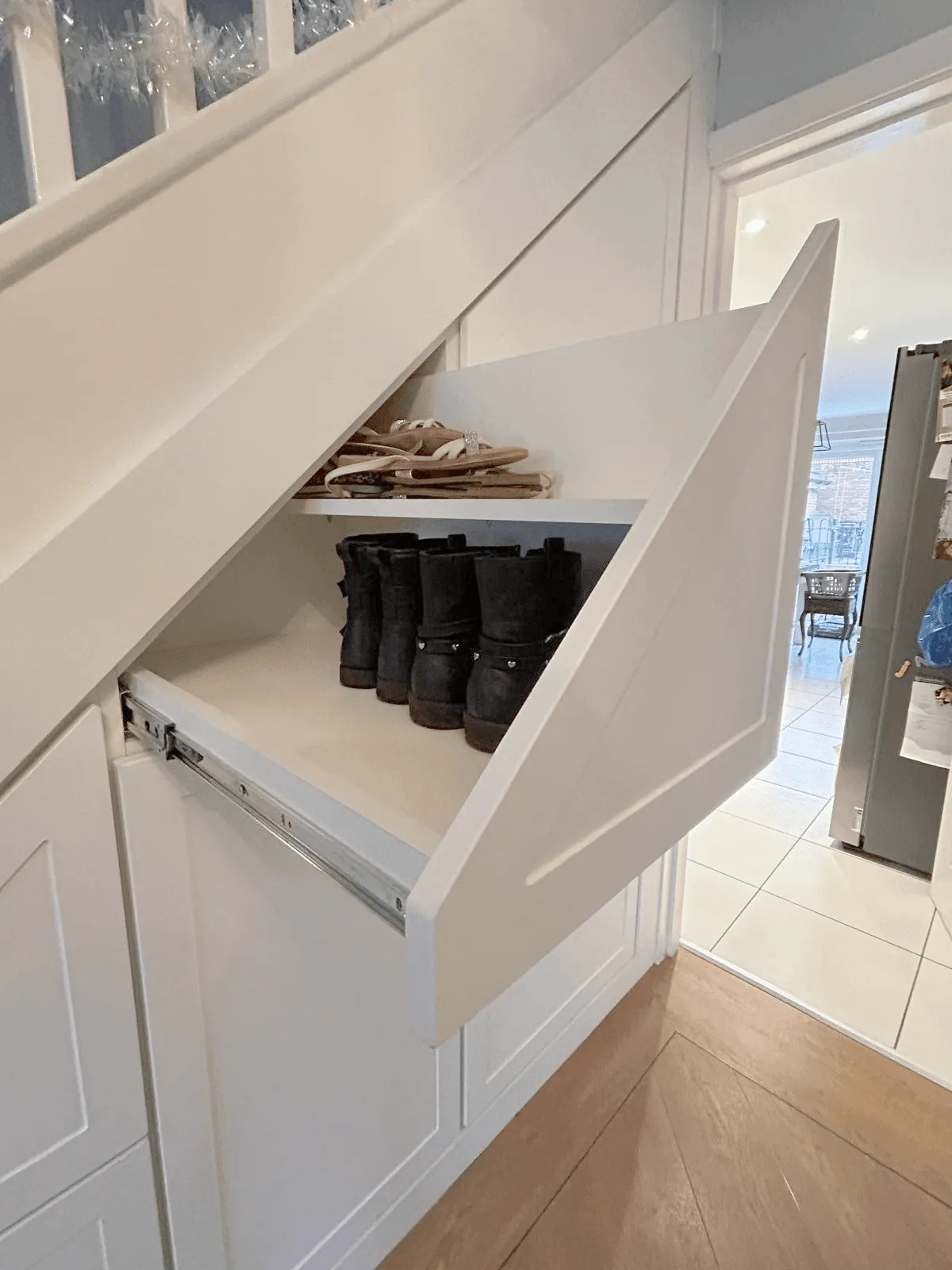 Angled pull out shoe drawer extended to show two tiers of shoes
