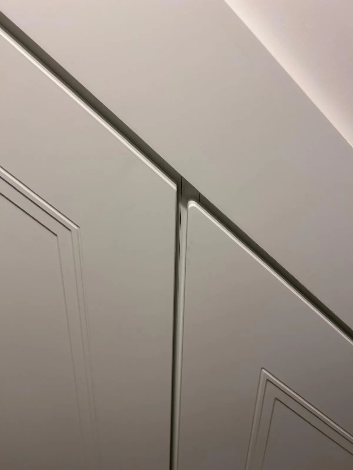 Close up of the signature 10mm shadow gap between white panelled under stairs doors